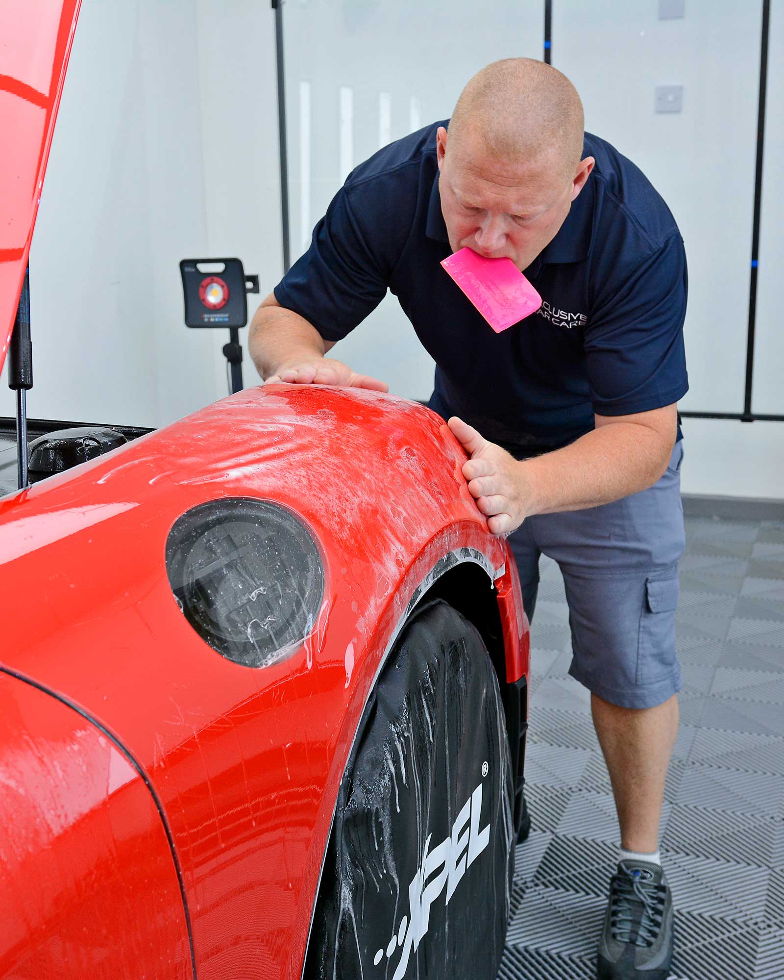 paint_protection_film PPF being applied to the front wing of a Porsche GT4